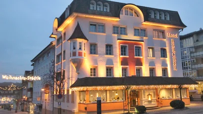 Beleuchtetes Hotel Bercher in der Abenddämmerung mit Weihnachtsbeleuchtung